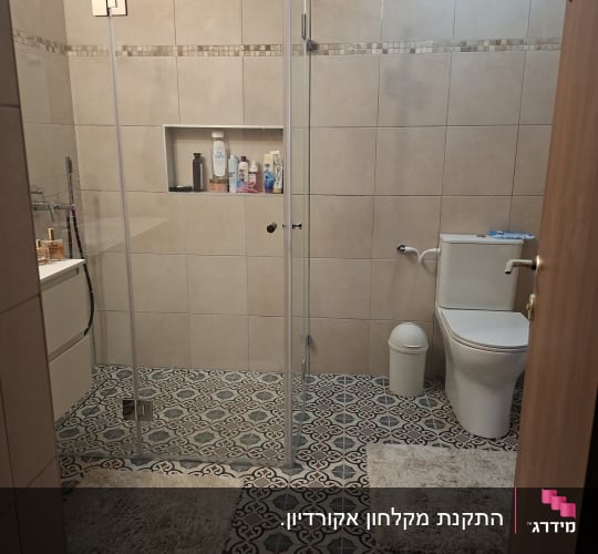 חדר אמבטיה עם מקלחון זכוכית ורצפת אריחים מעוצבת